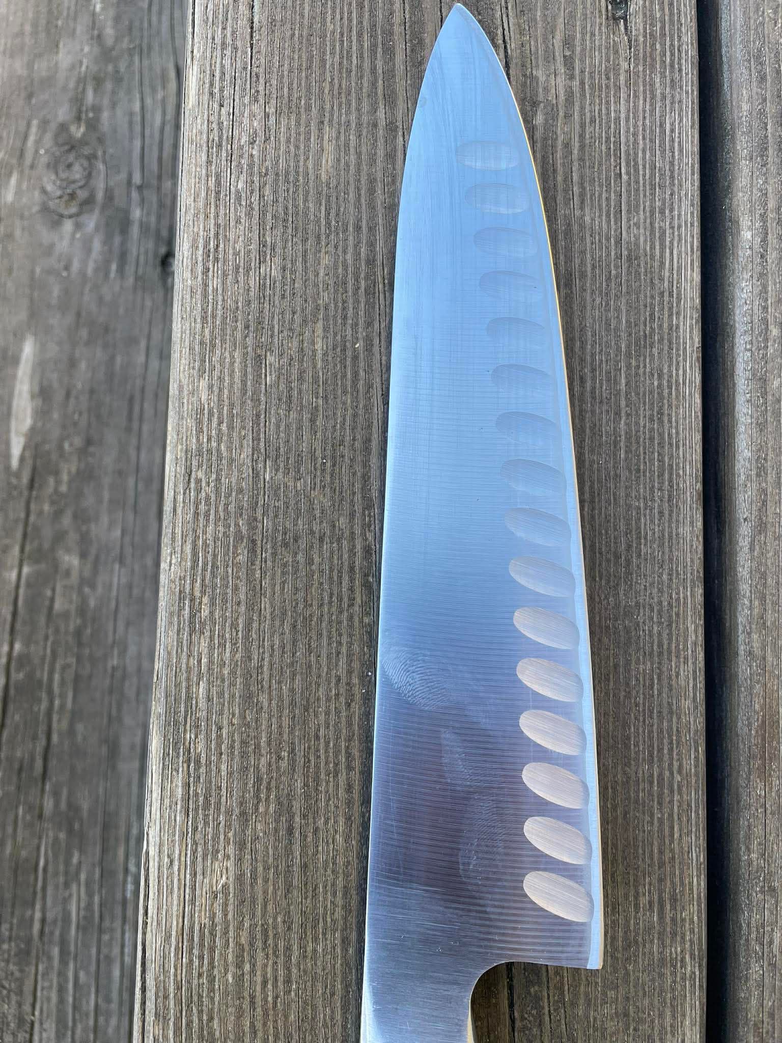 Köksslippad kockkniv med granton-egg på trälucka
